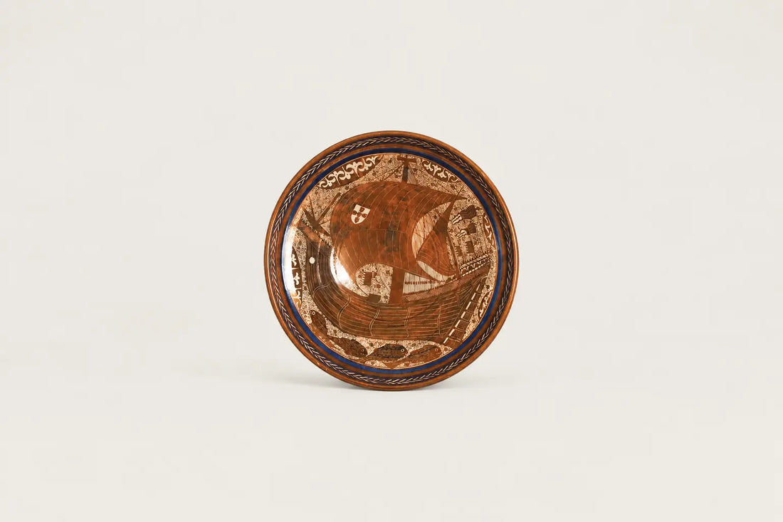 Hand-painted lustreware decorative plate featuring an ornate sailing ship motif in copper brown, cream and cobalt blue.