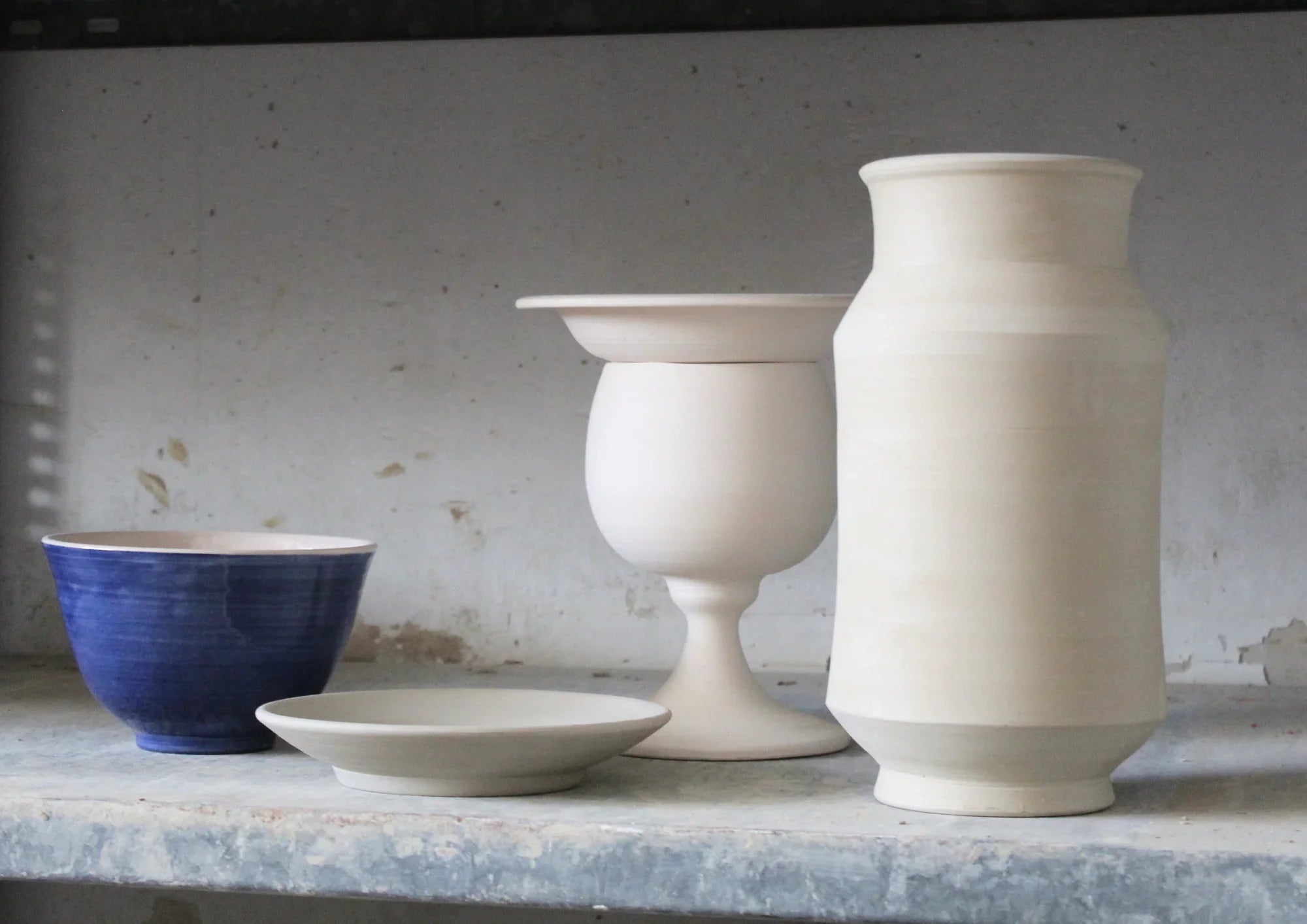 Tall handmade ceramic vases with tin glaze and lustreware finish – ideal for modern, sculptural floral arrangements.