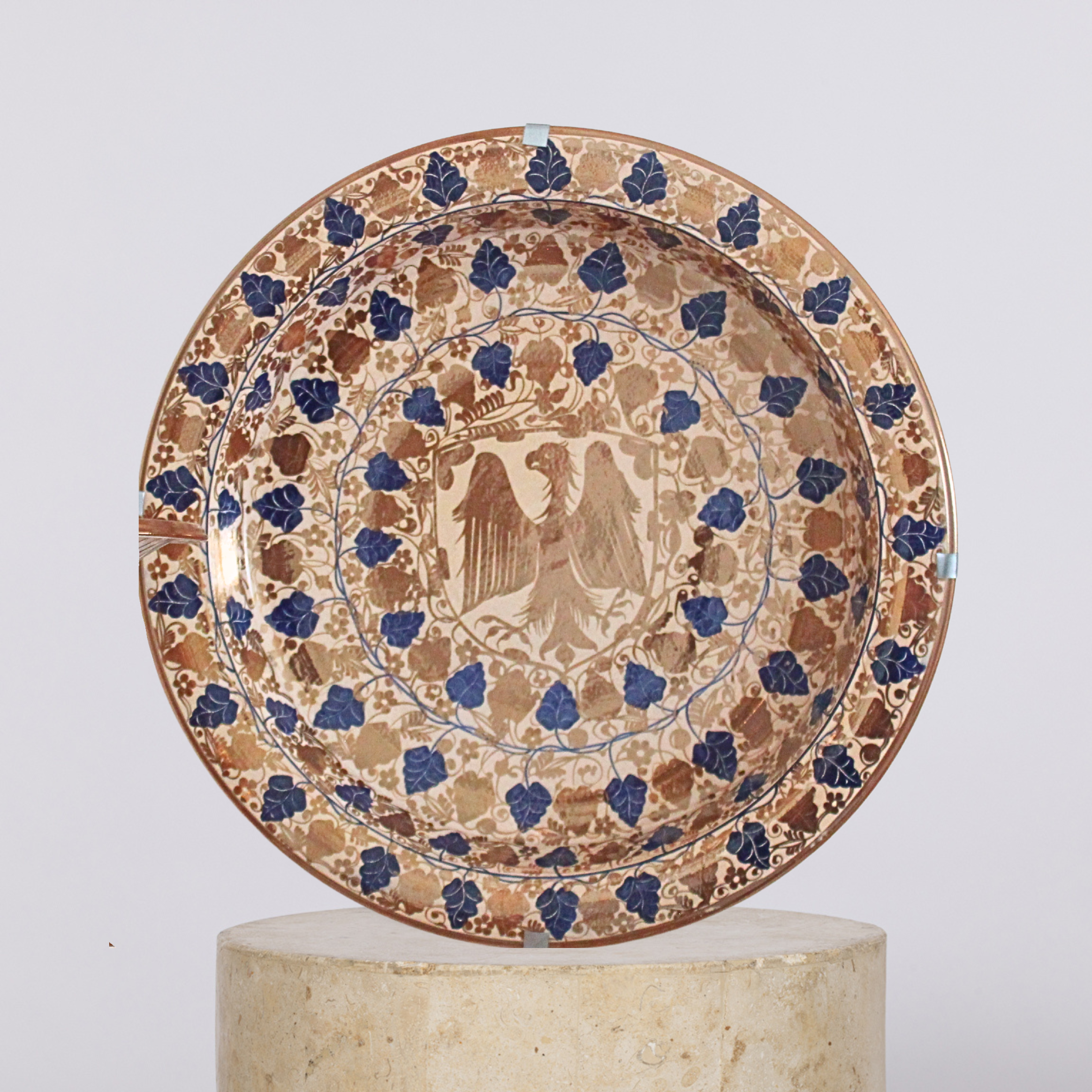 Decorative ceramic plate with intricate designs on a white background