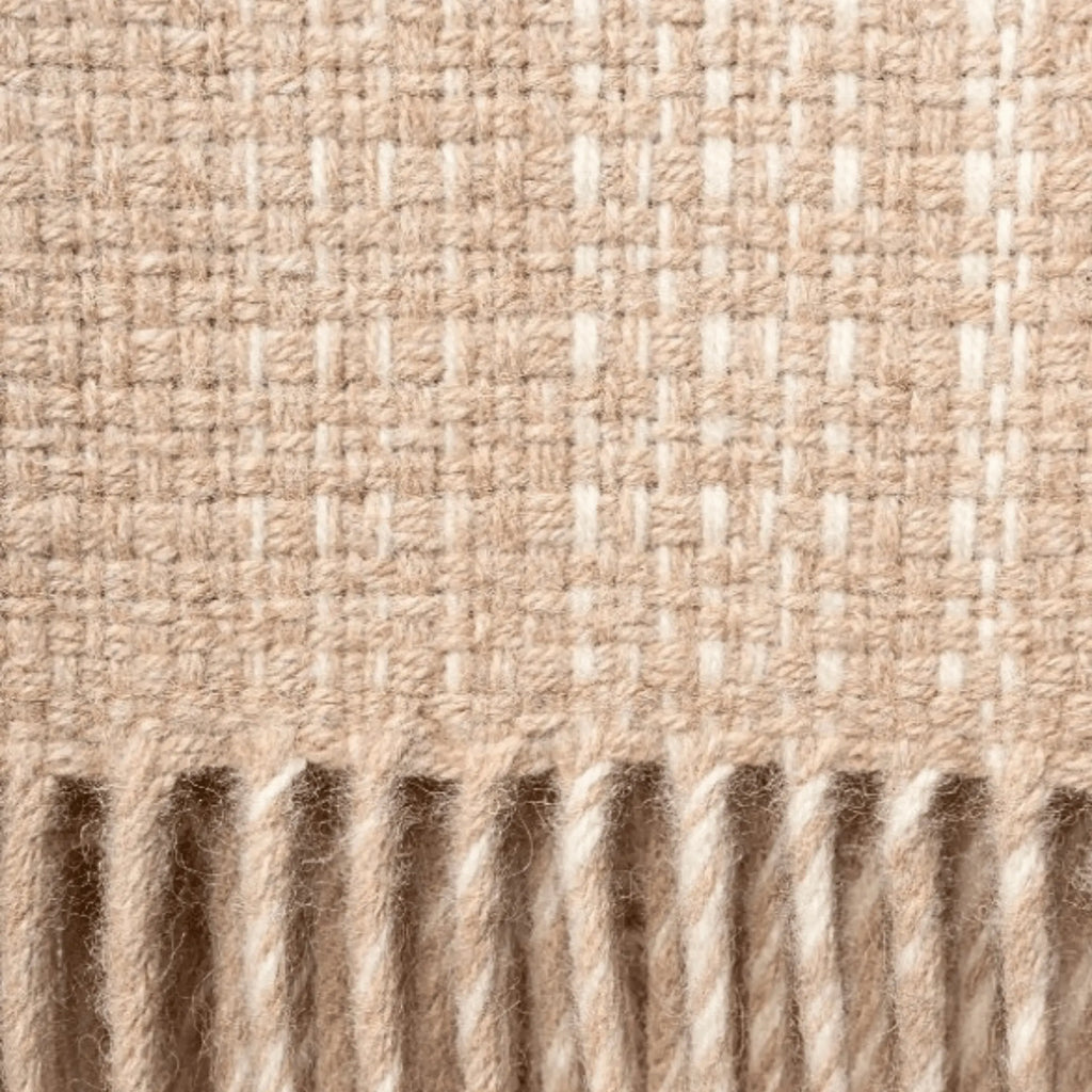 Close-up of woven throw blanket with a ribbed texture in vanilla and beige colours