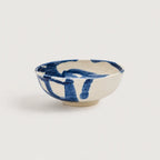 Ceramic snack bowl with blue abstract design on a white background