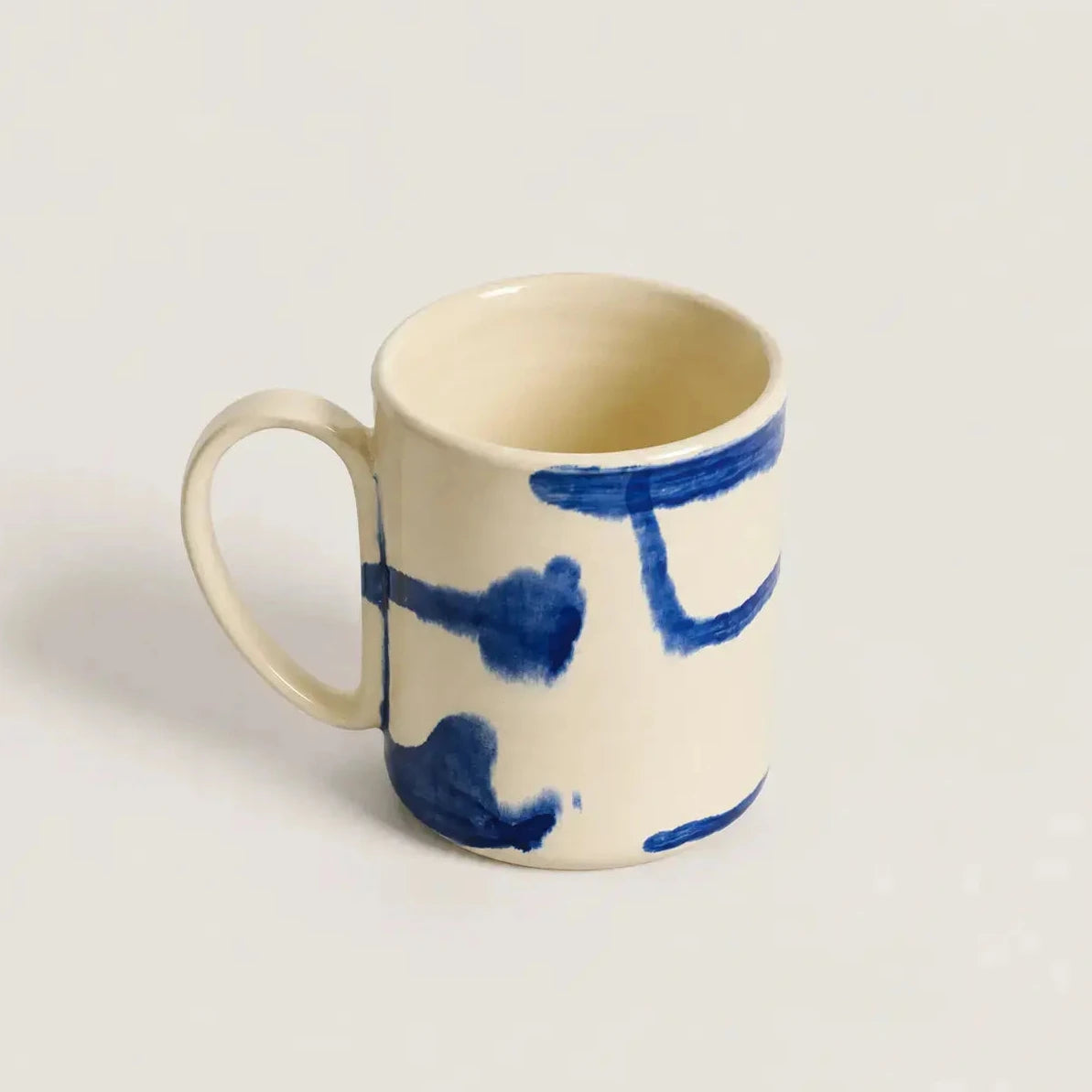 Porcelain mug with blue abstract designs on a light gray background