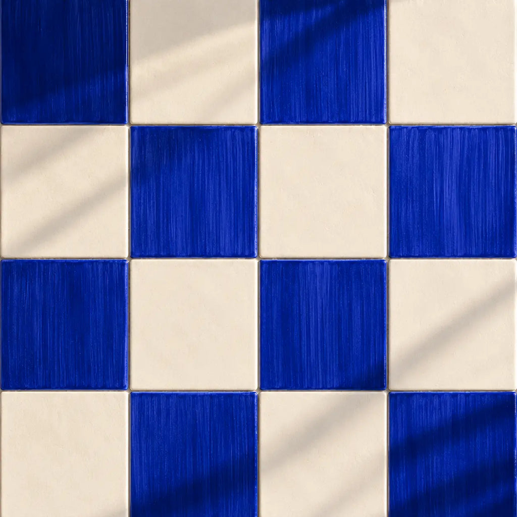 Blue and white checkered patterned tiles with a brushed metallic texture and soft diagonal shadows.