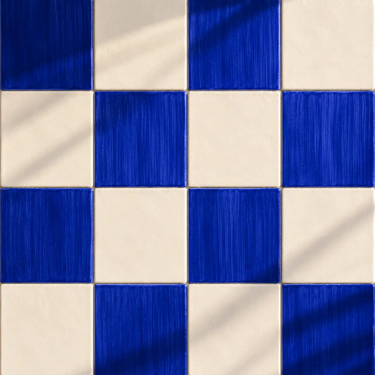 Blue and white checkered patterned tiles with a brushed metallic texture and soft diagonal shadows.