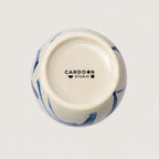 Ceramic container with blue marbled design and 'Cardoon Studio' logo on a light gray background