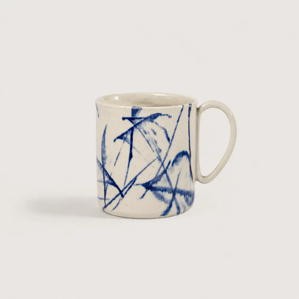 White mug with blue abstract patterns on a light gray background