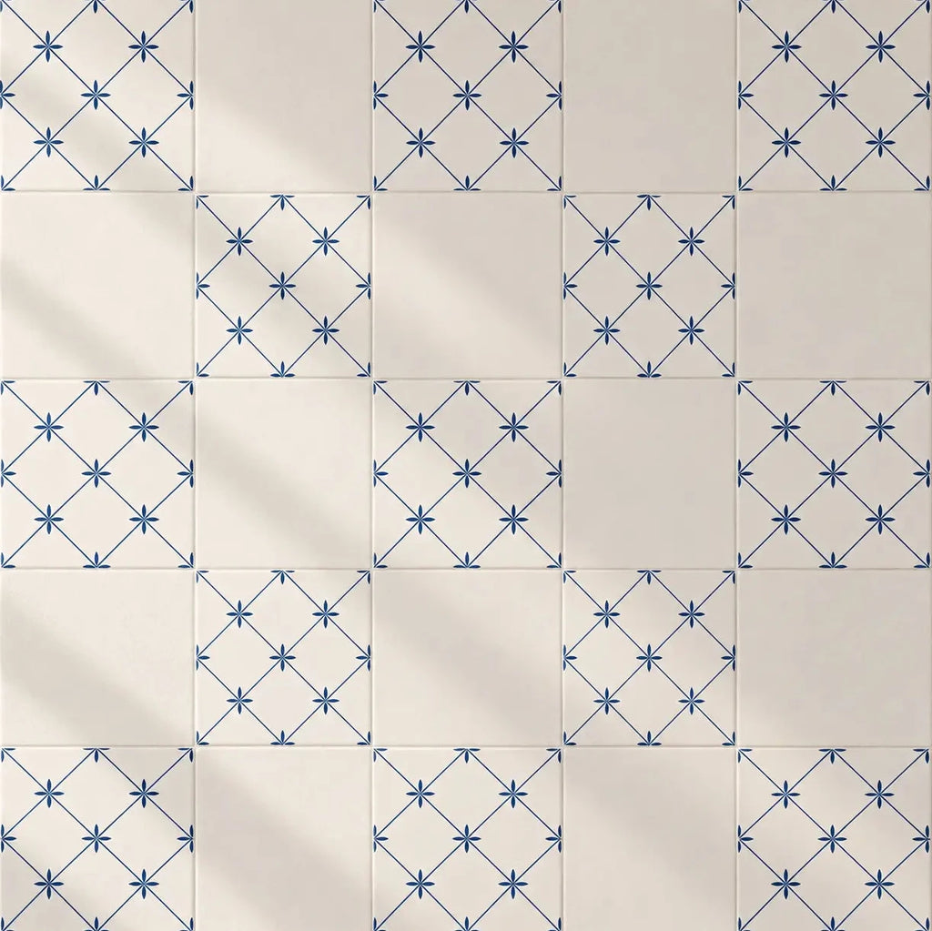 Square ceramic tiles arranged in a grid, featuring alternating patterns of solid cream tiles and tiles with a blue geometric star lattice design.
