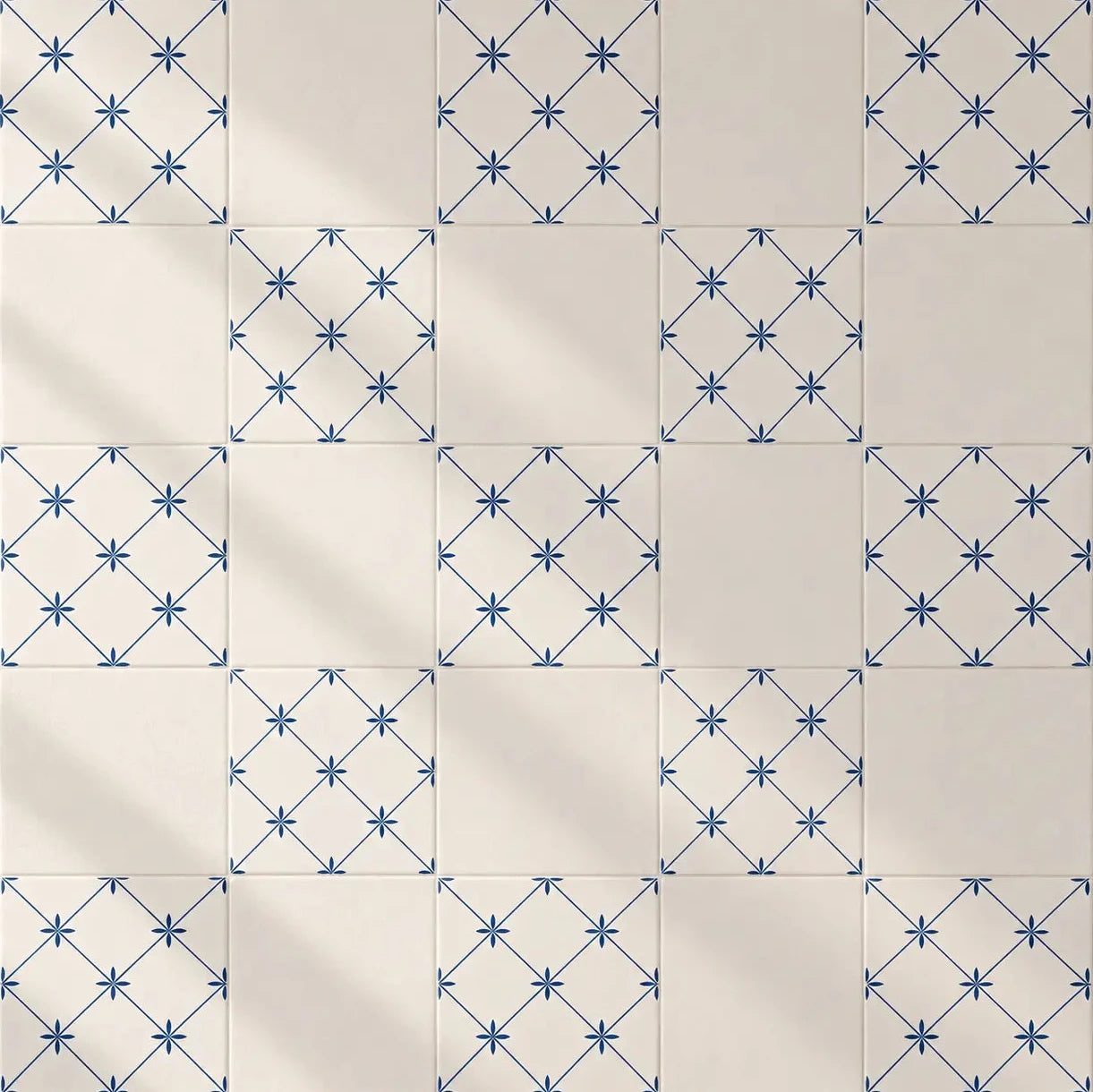 Square ceramic tiles arranged in a grid, featuring alternating patterns of solid cream tiles and tiles with a blue geometric star lattice design.