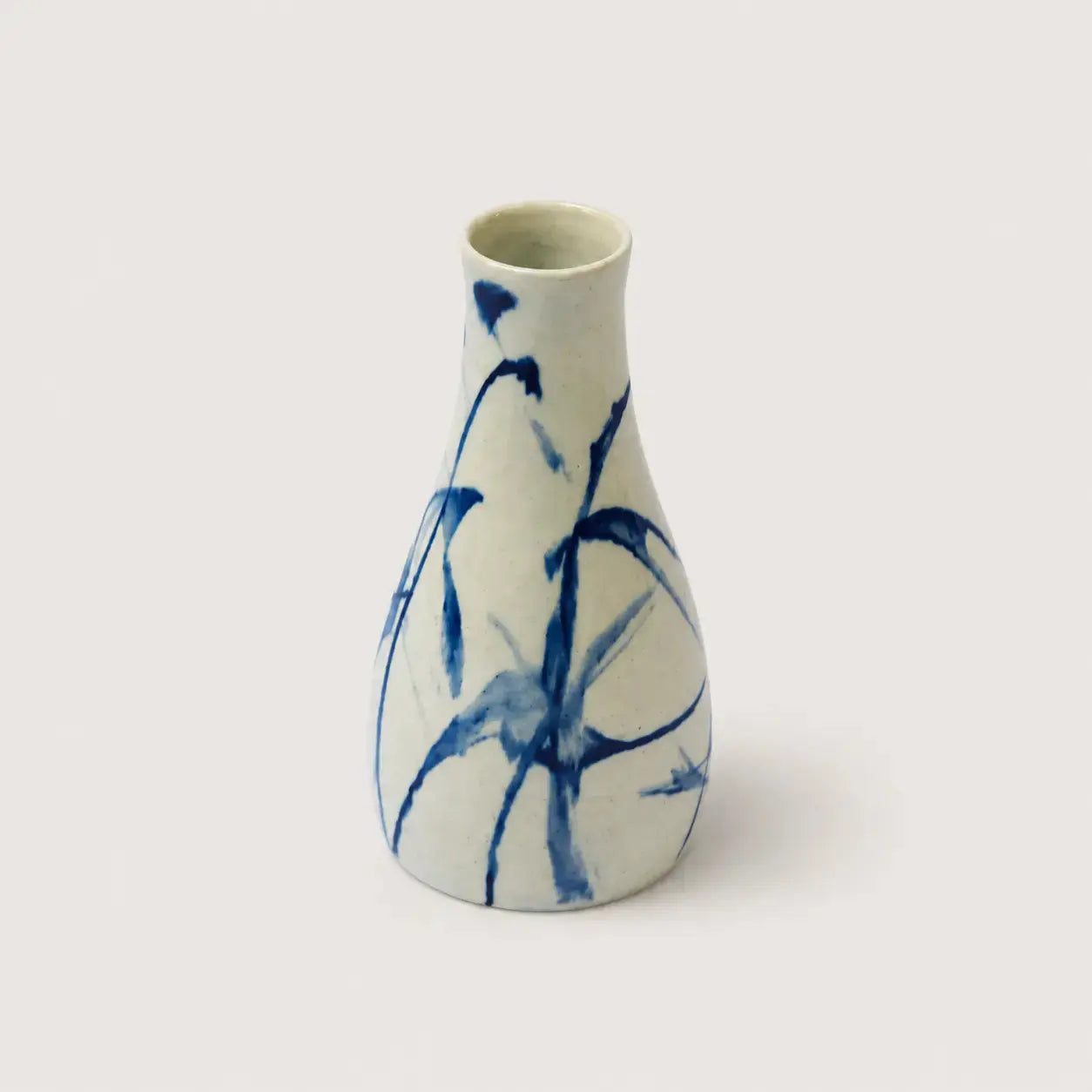 White ceramic vase with blue abstract patterns on a white background