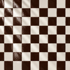 A stack of glossy square ceramic tiles in a deep chocolate brown colour, arranged on a textured off-white surface.