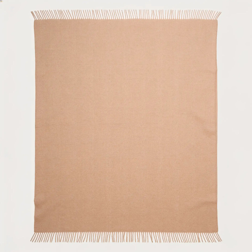 A rectangular beige alpaca throw blanket with fringed edges, laid flat against a clean white background.