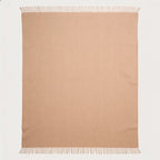 A rectangular beige alpaca throw blanket with fringed edges, laid flat against a clean white background.
