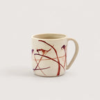 Ceramic mug with abstract red and black design on a white background