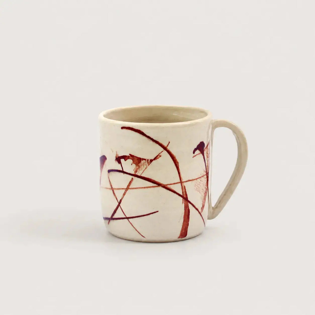 Porcelain mug with abstract red and black design on a white background