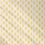 A repeating pattern of square tiles with a warm cream background and a metallic gold botanical leaf motif, arranged in a grid with thin grout lines.