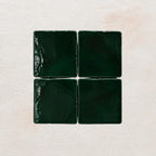 Four forest green square tiles on a textured beige background