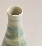 Ceramic vase with a gradient of green and blue on a plain background