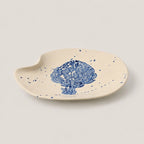 Ceramic dish with blue floral design on a beige background