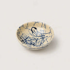 Ceramic snack bowl with blue abstract patterns on a beige background
