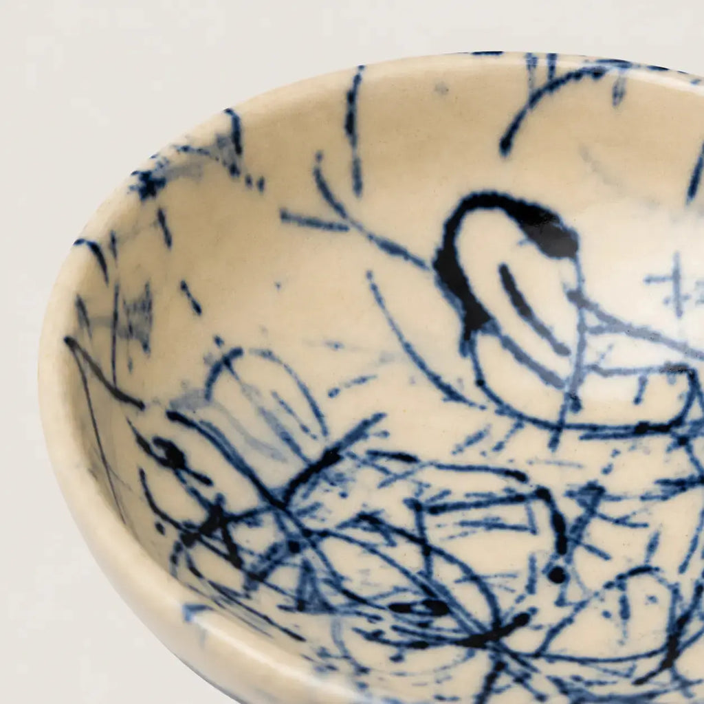 Ceramic snack bowl with blue abstract designs on a white background