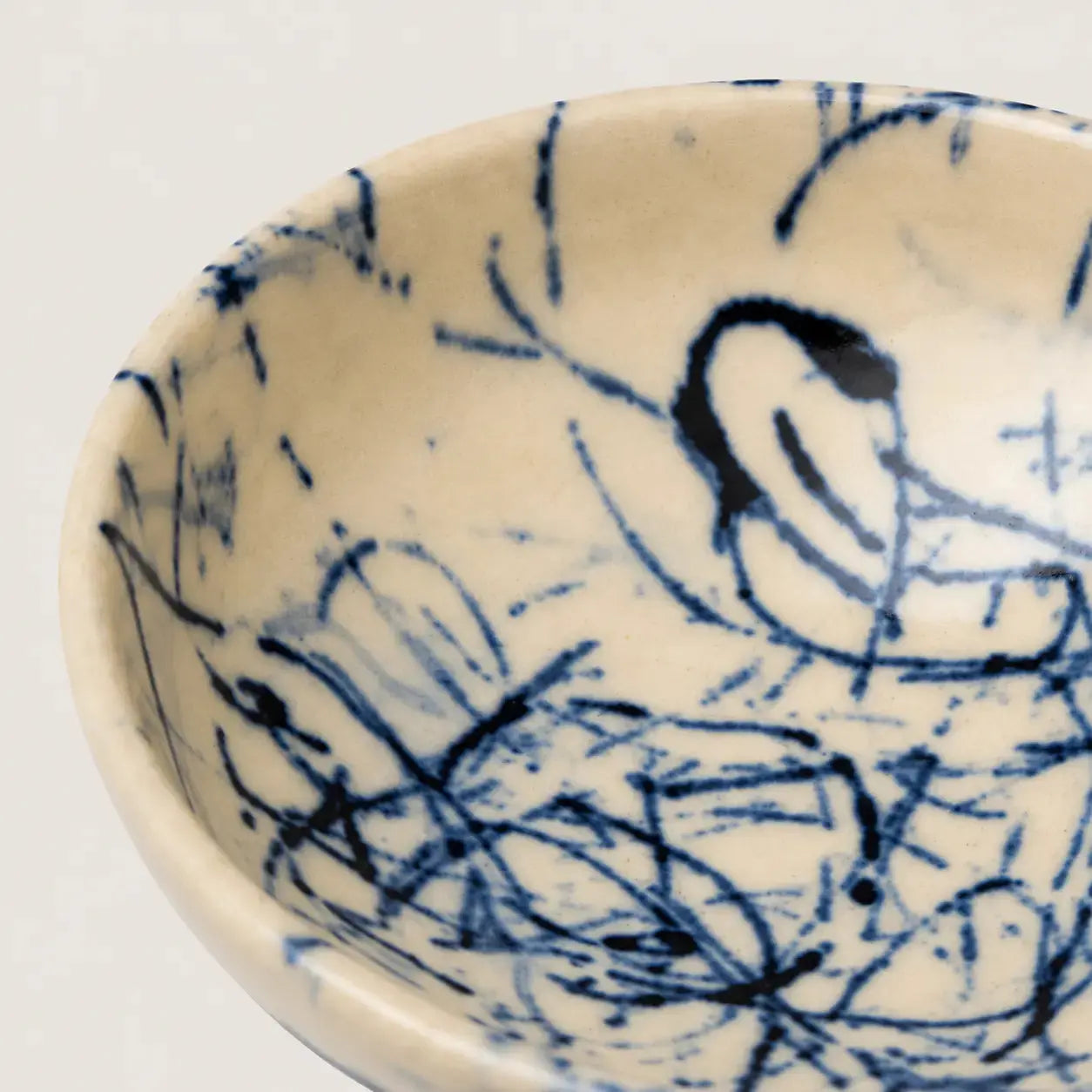 Ceramic snack bowl with blue abstract designs on a white background