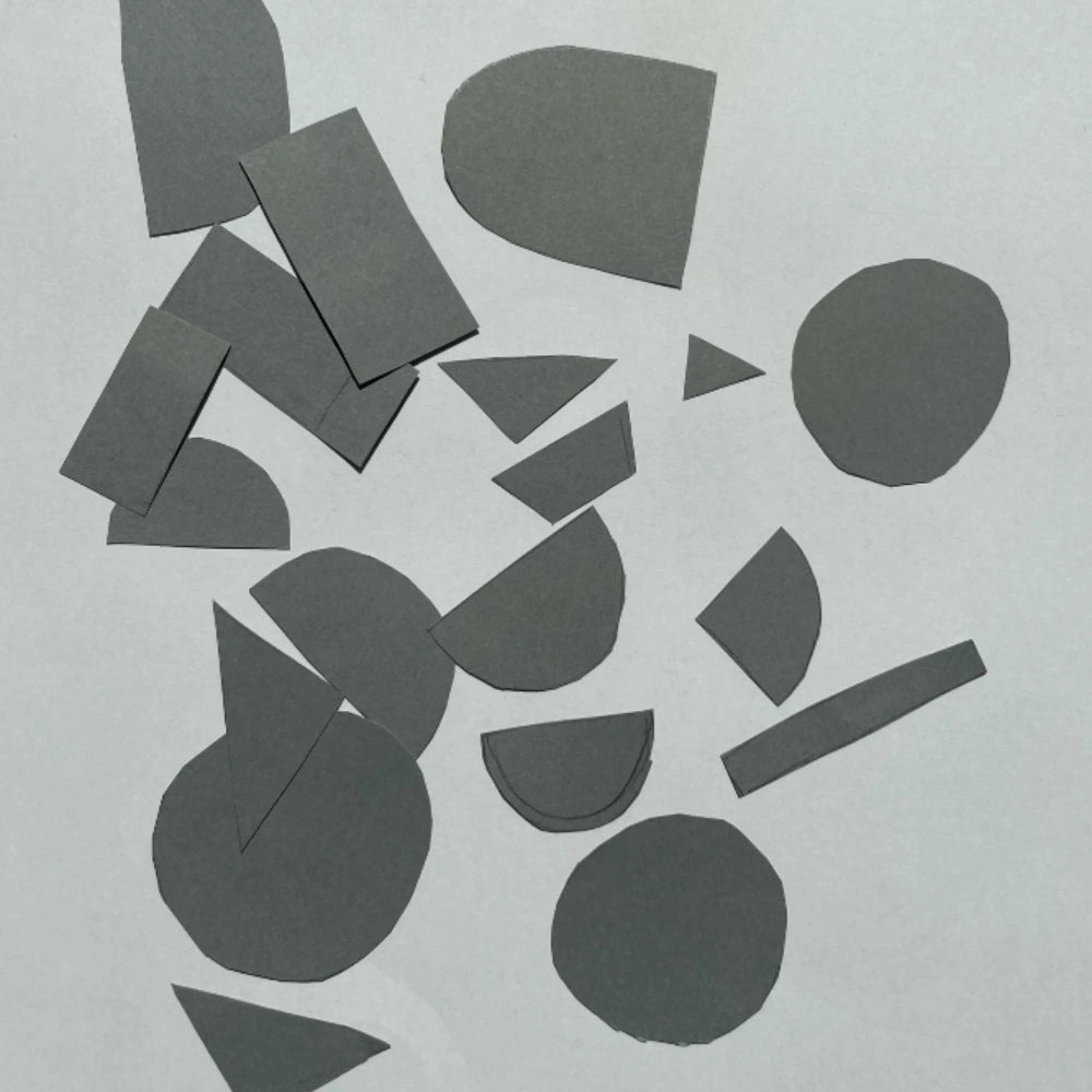 Cardoon Studio logo. Scattered dark gray paper shapes of circles, rectangles, triangles, and semi-circles on a light background.