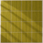 A 3x5 grid of square tiles in a warm olive-yellow or moss green color with a brushed texture, arranged on a light beige background with soft diagonal shadows.