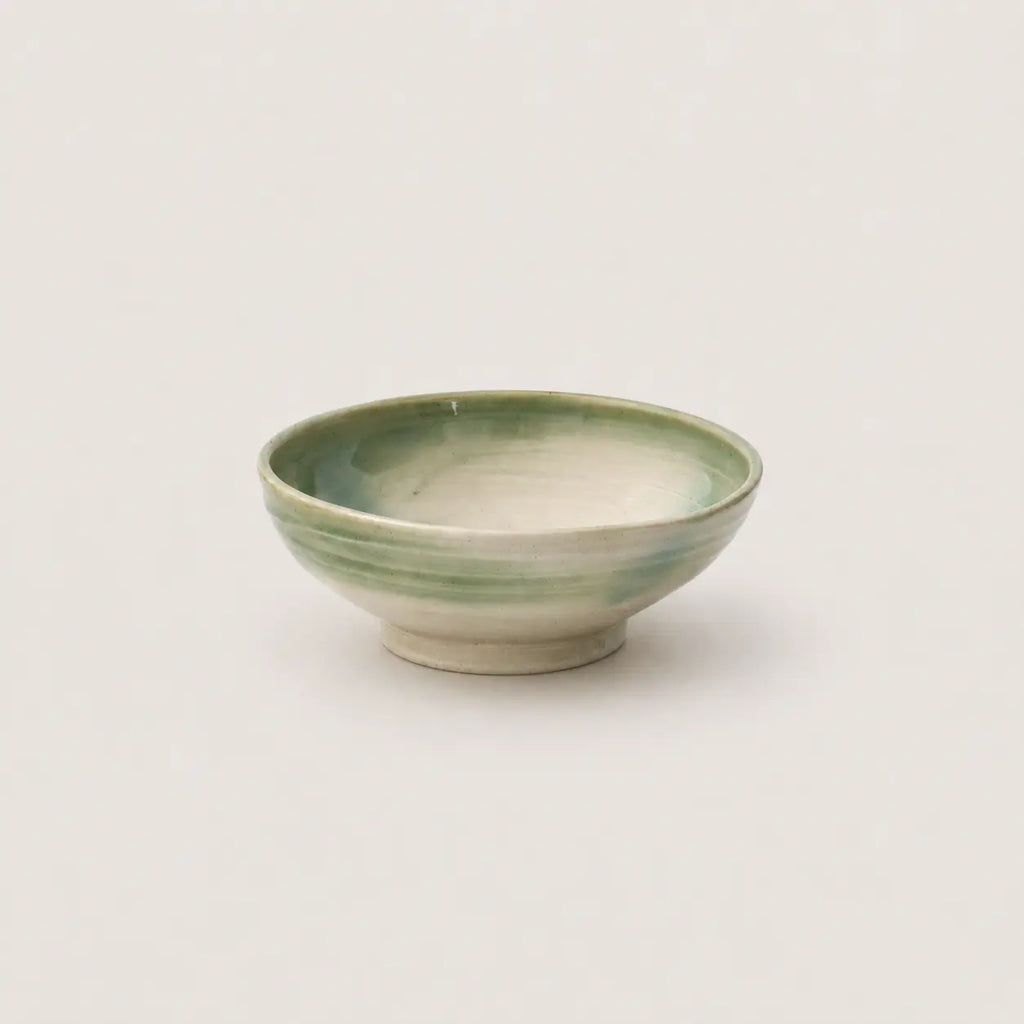 Green ceramic bowl on a light gray background