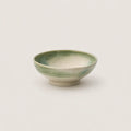 Green ceramic bowl on a light gray background