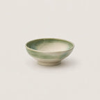 Green ceramic bowl on a light gray background