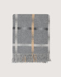 A gray woven throw blanket with a classic plaid pattern in white, black, and tan, finished with fringed edges, shown flat against a light beige background.