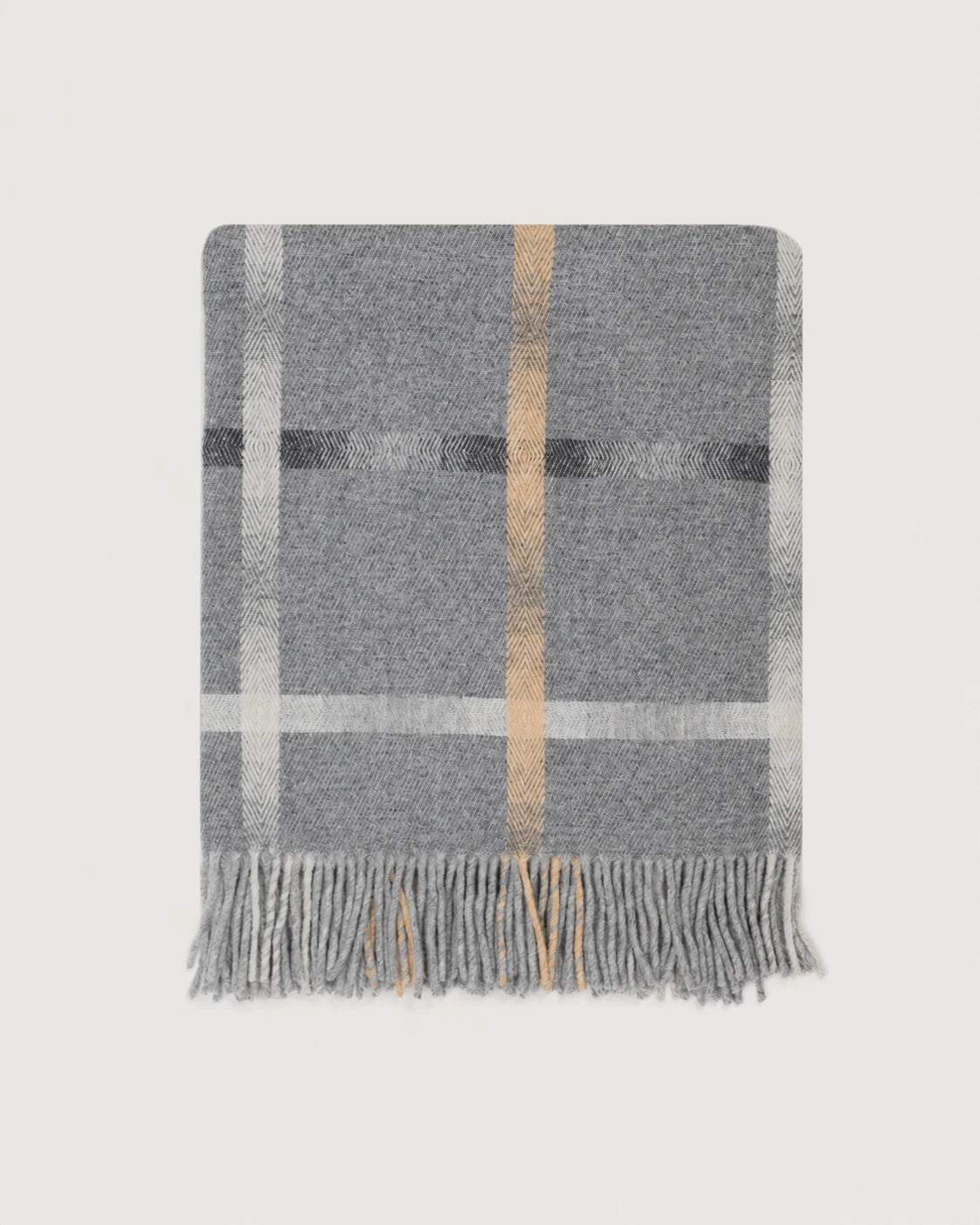 A gray woven throw blanket with a classic plaid pattern in white, black, and tan, finished with fringed edges, shown flat against a light beige background.
