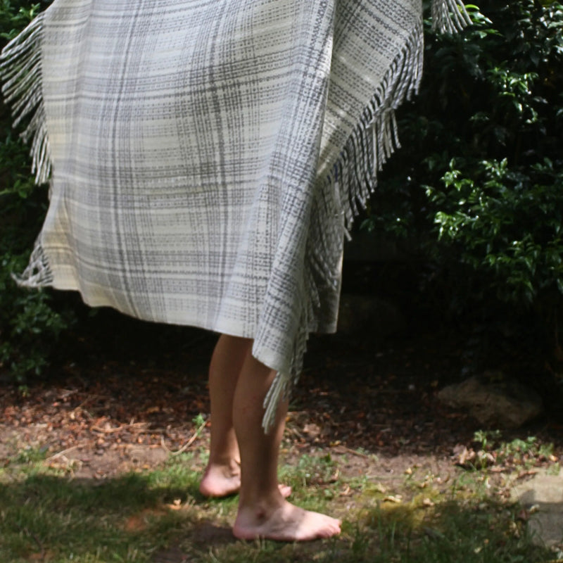 Cardoon Studio grey plaid throw blanket with fringed edges, versatile for cozy interiors or outdoor living.