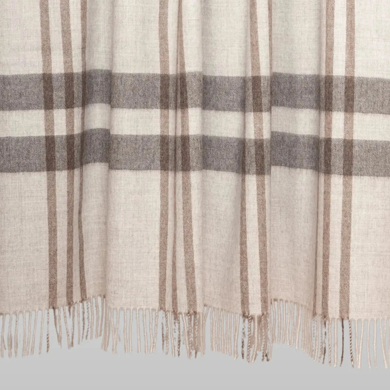 Plaid blanket with brown and gray stripes on a wooden stick against a white background