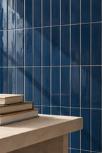 wall of glossy vertical ceramic tiles in mediterranean dark blue. Rectangular shape.