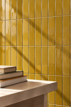 amber yellow rectangular gloss tile wall with table nearby