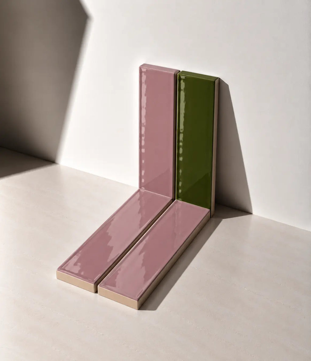 Glossy Dusty Pink and Olive Green handmade ceramic tiles arranged against a white wall in natural sunlight.