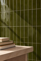 moss green rectangular gloss tile wall with table nearby