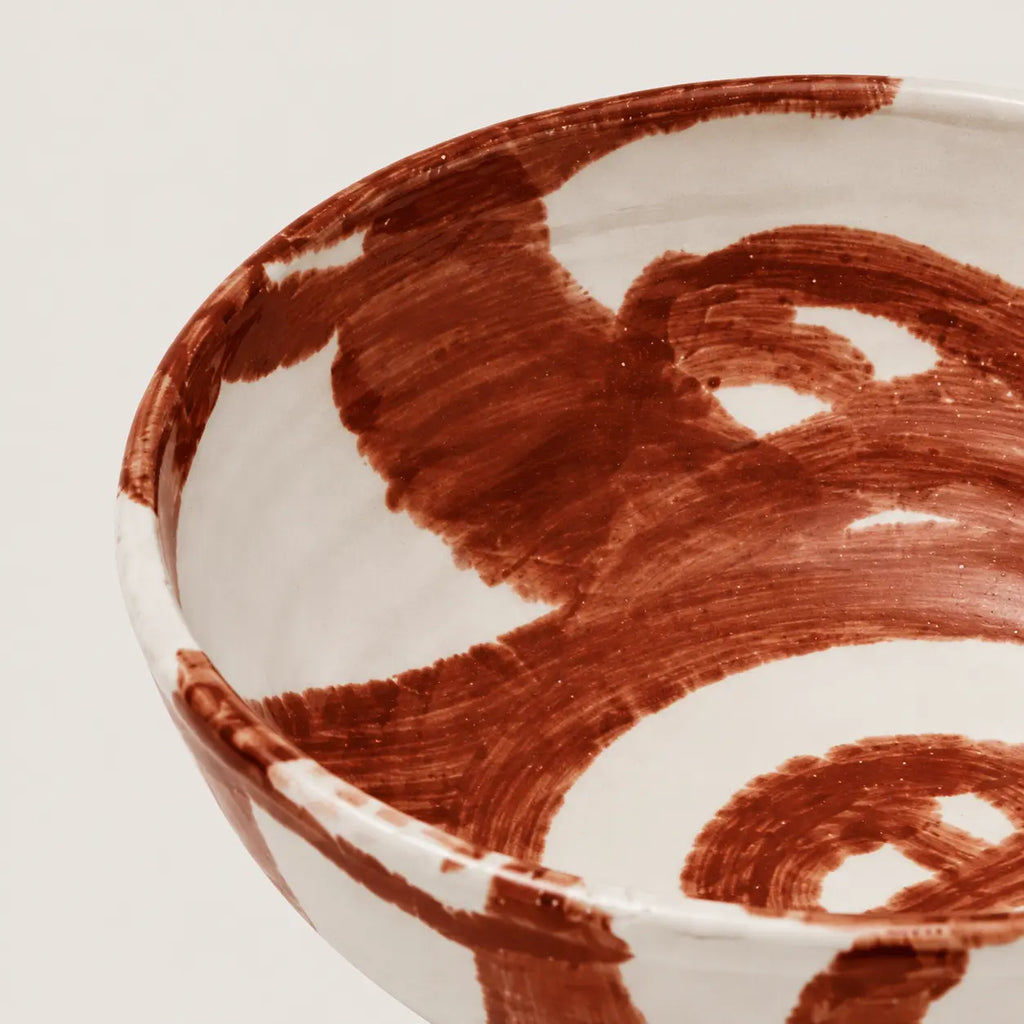 Ceramic snack bowl with brown abstract patterns on a light background