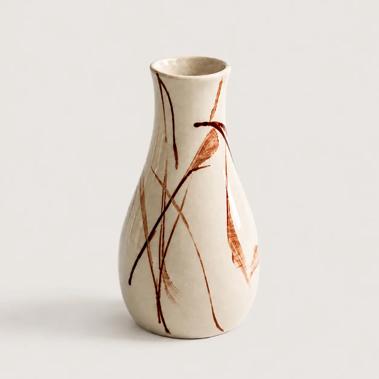 Ceramic vase with brown abstract patterns on a light gray background