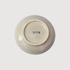 Underside of a handcrafted ceramic plate showing the Cardoon Studio stamp and smooth glazed finish.