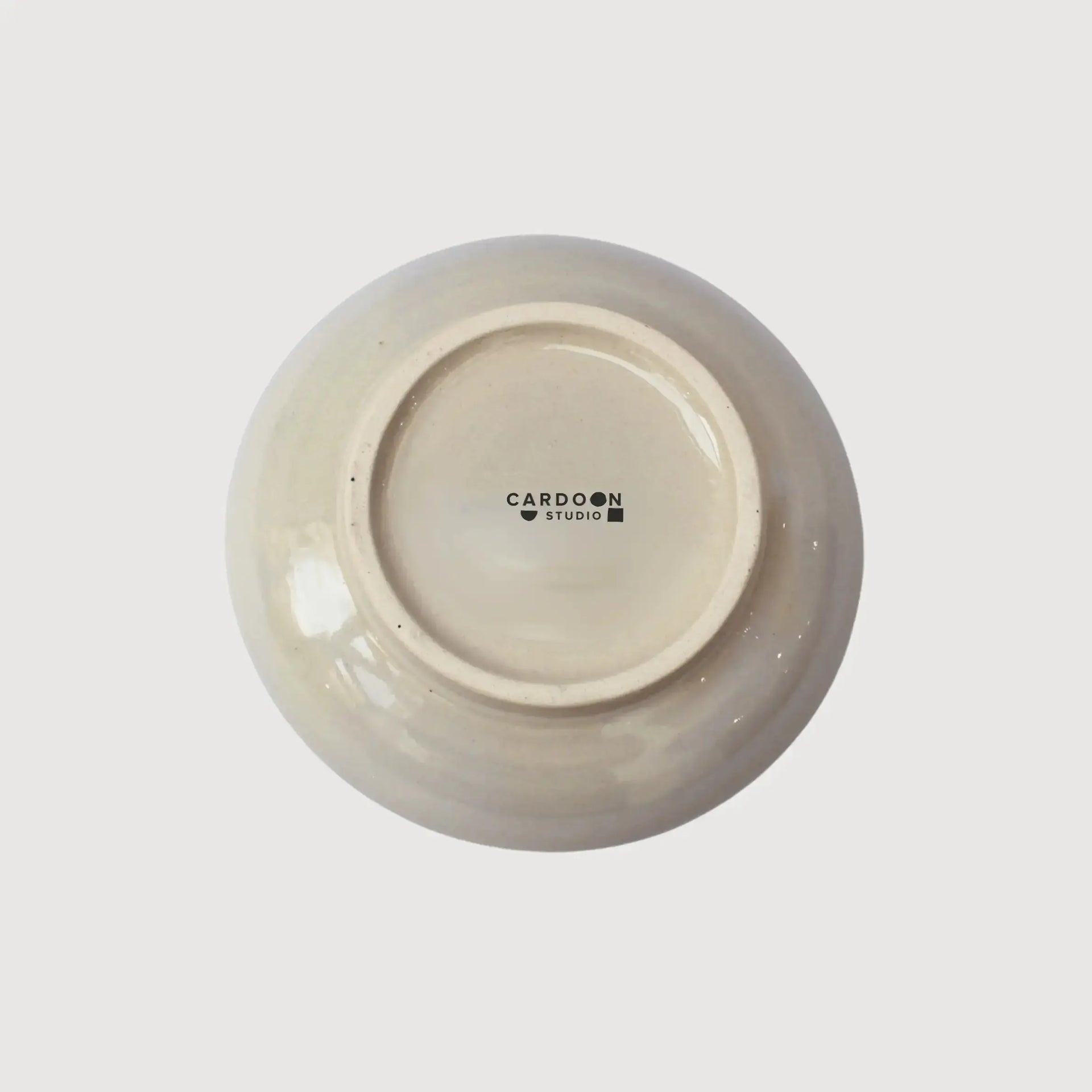 Underside of a handcrafted ceramic plate showing the Cardoon Studio stamp and smooth glazed finish.