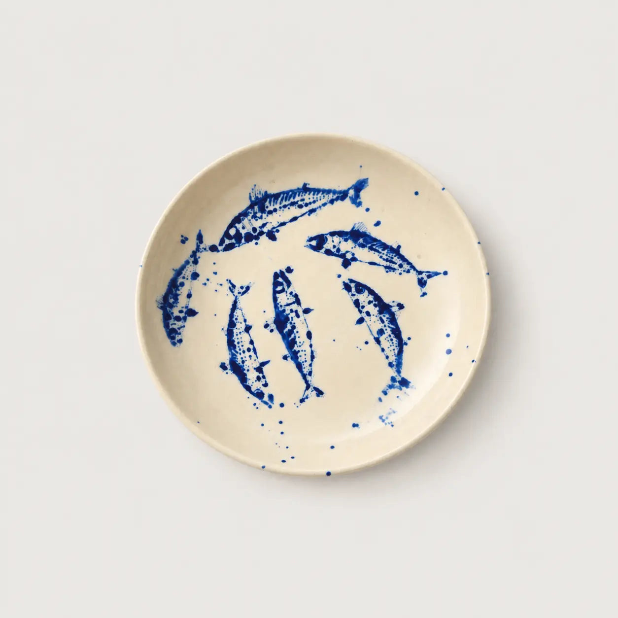 Ceramic plate with blue fish design on a white background