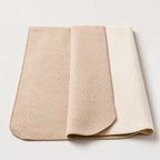 Semi reversible throw blanket with off-white stitched border in Alpaca