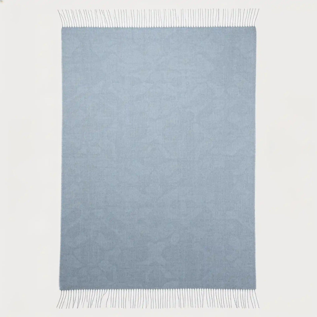 A rectangular light blue woven throw blanket with fringed edges, shown flat against a plain white background.