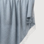 Gray blanket with fringe on a light gray background