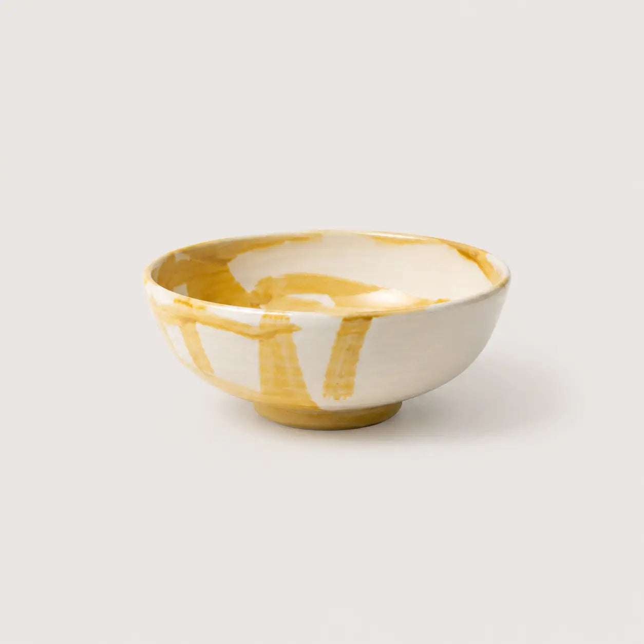 Ceramic bowl with yellow and white design on a light gray background