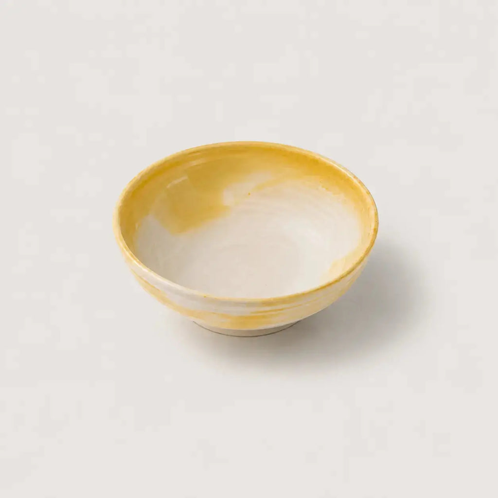 Yellow ceramic snack bowl on a light gray background