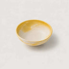 Yellow ceramic snack bowl on a light gray background