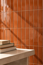 terracotta orange rectangular gloss tile wall with table nearby